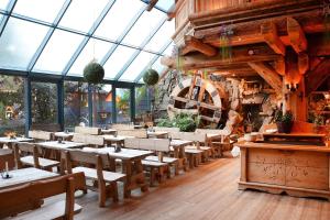 a restaurant with tables and chairs in a room with windows at Pokoje Krupówki 13 - Hotel Sabała in Zakopane