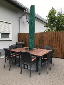 a wooden table with chairs and a green curtain on it at Ferienhaus Auf der Hill in Büdesheim