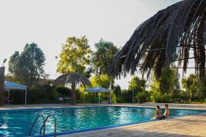 two women sitting in the pool at a resort at Azraq Rest House in Al Azraq ash Shamālī