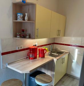a small kitchen with a sink and red appliances at M24 in Hecklingen