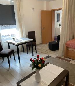 a living room with a table and a vase with flowers on it at M24 in Hecklingen