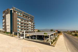 a building with a parking lot next to a road at ARTES HOTEL in Hatay