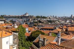 vistas a una ciudad con tejados y un puente en CLUBE Charming Apartments - Ribeira, en Oporto