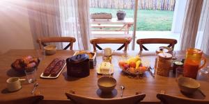 einen Holztisch mit Essen darüber in der Unterkunft Bel Canto - Chambres d'hôtes Plateau de sault in Roquefeuil