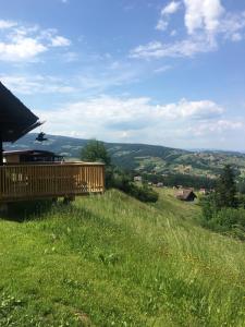 a wooden deck on a hill with a green field at Ferienhaus Trausibauer in Stainz