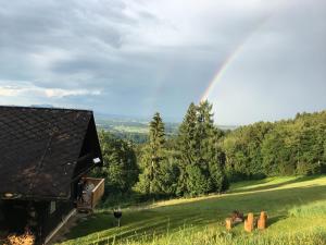 a rainbow over a green field with a house at Ferienhaus Trausibauer in Stainz