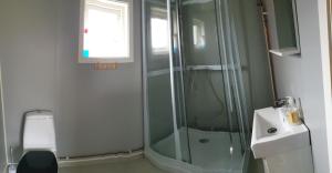 a bathroom with a glass shower and a sink at Solvang camping og leirsted in Alta