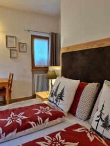 a bedroom with a bed with red and white pillows at B&B Ai Larici in Bocenago