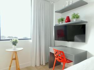 a bedroom with a red chair and a tv at 1 on Albert Building in Cape Town