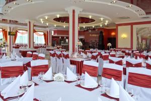 a banquet hall with white tables and red chairs at Sobkoff in Khmelʼnytsʼkyy