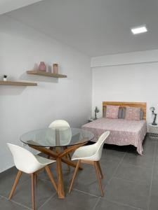 ein Schlafzimmer mit einem Glastisch, 2 Stühlen und einem Bett in der Unterkunft Enjoy Las Canteras in Las Palmas de Gran Canaria