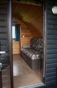 uma sala de estar com um sofá numa cabana de madeira em Rockinghams Farm em Layer Marney
