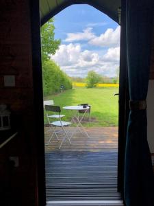 Layer Marney的住宿－Rockinghams Farm，透过门可欣赏到桌椅的景色