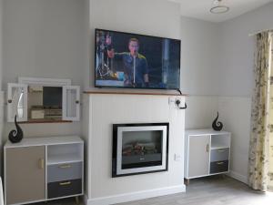 a living room with a tv above a fireplace at 3 Bedroom Home with Welcome Breakfast near Beaches in Ramsgate