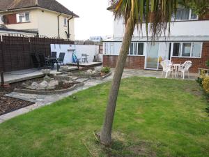 a palm tree in the yard of a house at 3 Bedroom Home with Welcome Breakfast near Beaches in Ramsgate