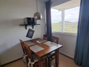 a dining room table with chairs and a window at Apartment Harzblick in Bad Lauterberg