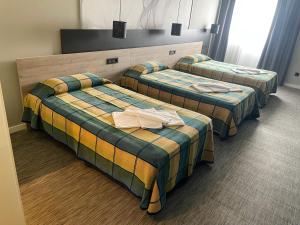 Habitación de hotel con 3 camas y toallas. en Area 507, en Outeiro de Rei
