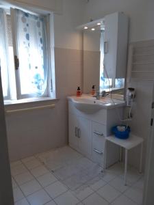 ein weißes Badezimmer mit einem Waschbecken und einem Spiegel in der Unterkunft alloggio verona est S. Pietro in Lavagno