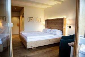 a bedroom with a large bed with white sheets and pillows at Hotel garni Kranzbichlhof in Dürrnberg