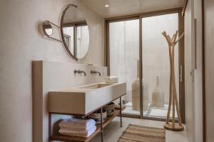 a bathroom with a sink and a mirror at Altera cave villas in Agios Pavlos