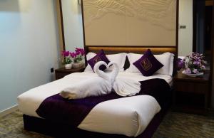 two swans laying on a bed in a hotel room at Lavona Tiba Hotel in Dammam