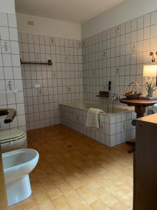 een badkamer met een bad, een toilet en een wastafel bij Casa Montana 1600 in Sovramonte