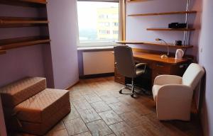 ein Büro mit einem Schreibtisch, einem Stuhl, einem Schreibtisch und einem Fenster in der Unterkunft Studio 1 in Warschau