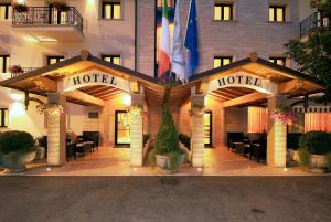 a hotel entrance with tables and chairs in front of it at Fashion Hotel in Valmontone