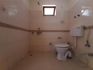 een badkamer met een wit toilet en een raam bij Rabyang Guest House and Homestay in Leh