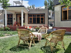 3 sedie e un tavolo di fronte a una casa di Rabyang Guest House and Homestay a Leh