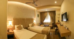 Katil atau katil-katil dalam bilik di Hotel Riveria by Raj