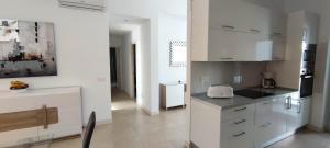 une cuisine avec des placards blancs et un comptoir noir dans l'établissement Villa Cástor, à Playa Blanca