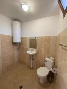 a bathroom with a toilet and a sink at Къща за гости Краси in Krapets +46 photos