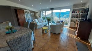 a living room with a couch and a table and chairs at Le Jardin du Cannet in Bagnols-en-Forêt