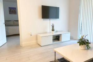 Una sala de estar con un televisor en la pared. en Comfortable 2 BR at Brickell , Free Parking, en Miami