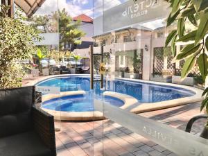 a reflection of a swimming pool in the window of a hotel at Отель Астель Вилла in Gelendzhik