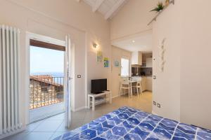 a bedroom with a bed and a television and a balcony at COME A CASA 19 - Romantic Studio in Massino Visconti