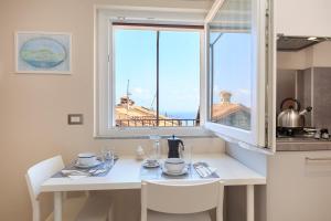 une cuisine avec une table blanche et une fenêtre dans l'établissement COME A CASA 19 - Romantic Studio, à Massino Visconti