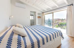 a white bedroom with a bed and a large window at Cyprus Villages Hotel & Restaurant - Central Location - Bed & Breakfast - With Access To Pool And Stunning Views in Tochni