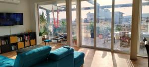 a living room with a blue couch and a large window at 110 sq.m. stunning Penthouse with large terrace in St. Paul's Bay