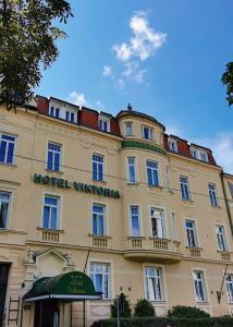 ein großes Gebäude mit einem Schild auf der Vorderseite in der Unterkunft Hotel Viktoria Schönbrunn in Wien