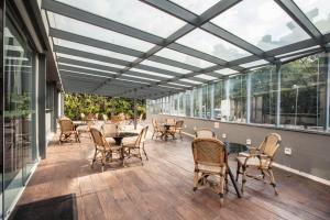 a conservatory with a table and chairs on a patio at Hotel WZ Jardins in São Paulo