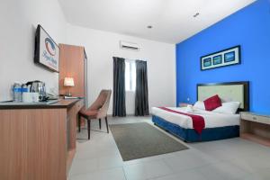 ein Hotelzimmer mit einem Bett und einem Schreibtisch in der Unterkunft Royal Agate Beach Resort in Pantai Cenang