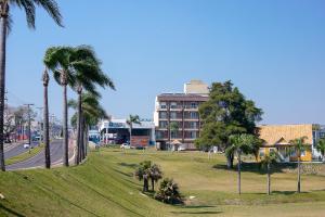 un parque con palmeras frente a un edificio en Royal Trip Hotel, en Guarapuava