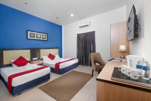 ein Hotelzimmer mit zwei Betten und einem Schreibtisch in der Unterkunft Royal Agate Beach Resort in Pantai Cenang + 31 Fotos