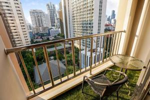 a balcony with a table and chair and a view of the city at Grand Asoke Suites Boutique Residence in Bangkok