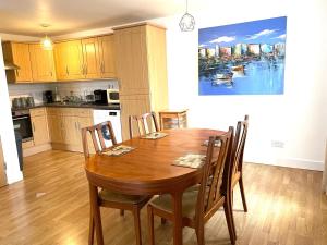 a kitchen with a wooden dining room table with chairs at Modern Apartment near Tower Bridge in London