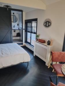 a bedroom with a bed and a table and a window at Kavel 90 in Den Burg +3 photos