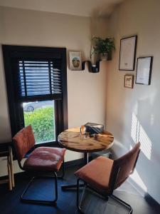 una camera con tavolo, sedie e finestra di Kavel 90 a Den Burg