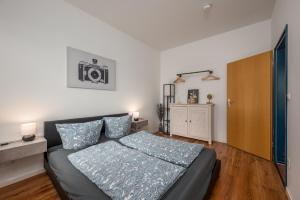 a bedroom with a bed with blue pillows on it at Arbio I Homely Apart in Sudvorstadt Leipzig in Leipzig